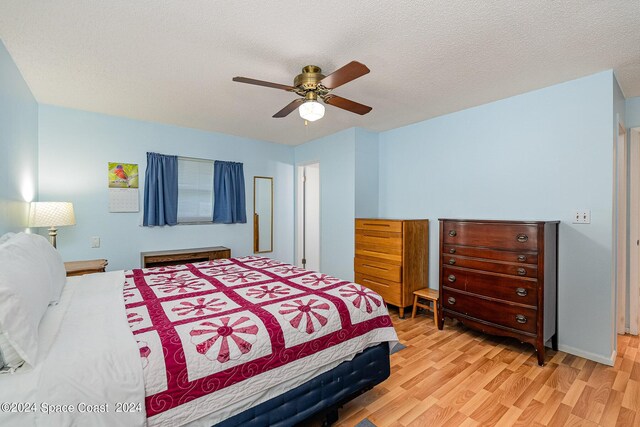 bedroom featuring a textured ceiling, light hardwood / wood-style flooring, and ceiling fan