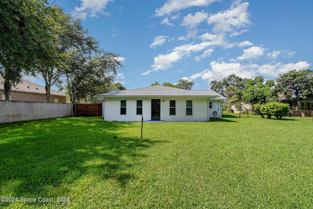 rear view of property with a yard