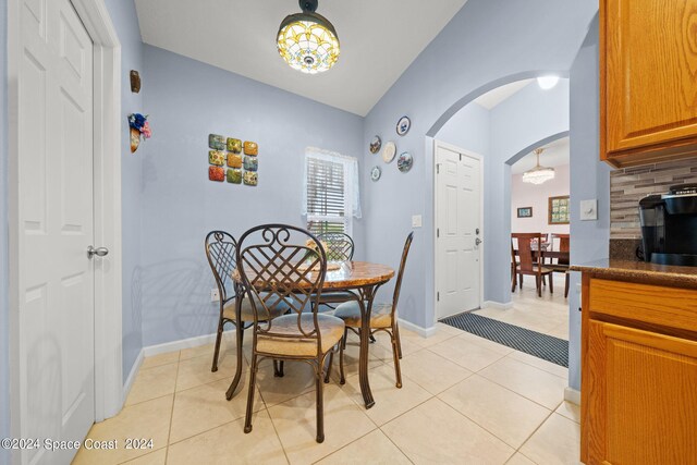 tiled dining space with vaulted ceiling