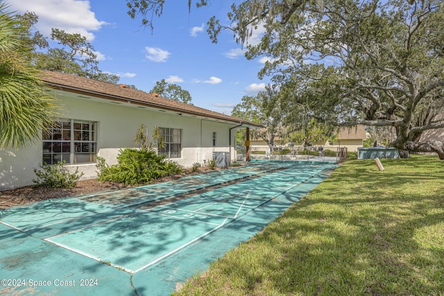 view of yard featuring central air condition unit and shuffleboard