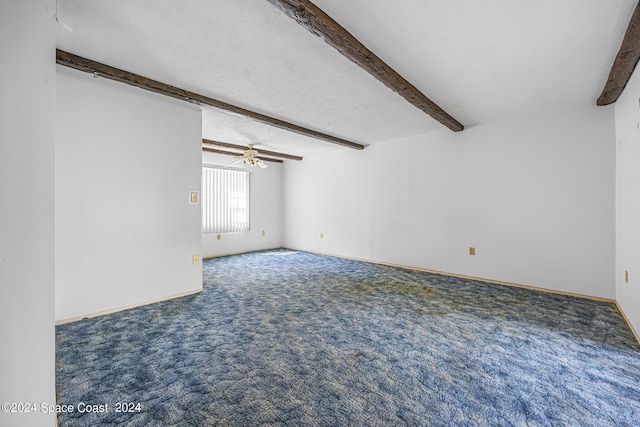 unfurnished room with baseboards, ceiling fan, beamed ceiling, carpet, and a textured ceiling