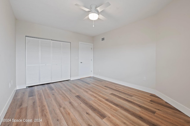 unfurnished bedroom with light wood-type flooring, a closet, and ceiling fan