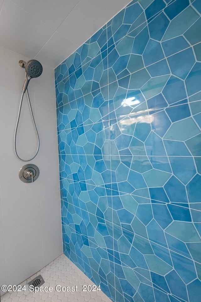 bathroom featuring tiled shower and tile patterned flooring