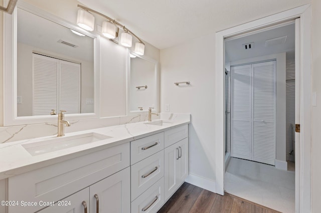 bathroom with wood-type flooring, a textured ceiling, and vanity