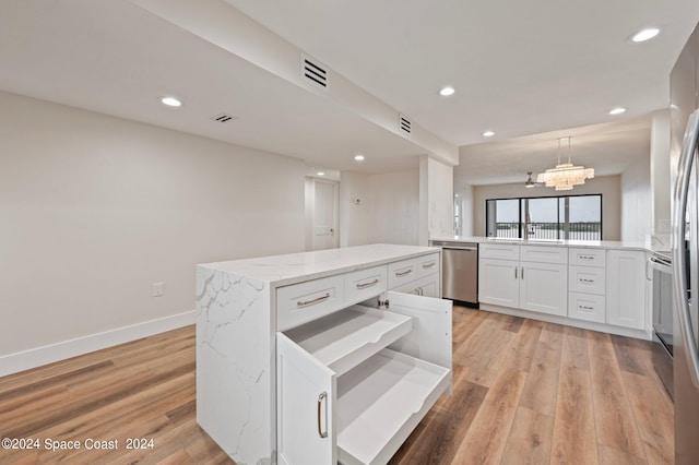 kitchen featuring light wood-type flooring, pendant lighting, dishwasher, and a center island