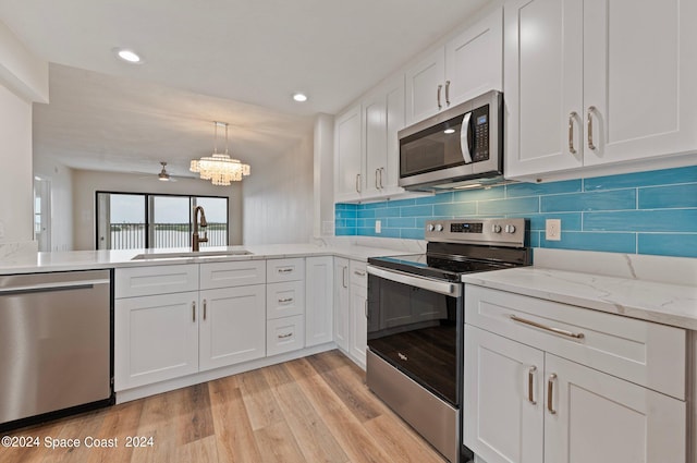 kitchen featuring light wood-type flooring, sink, appliances with stainless steel finishes, and white cabinetry