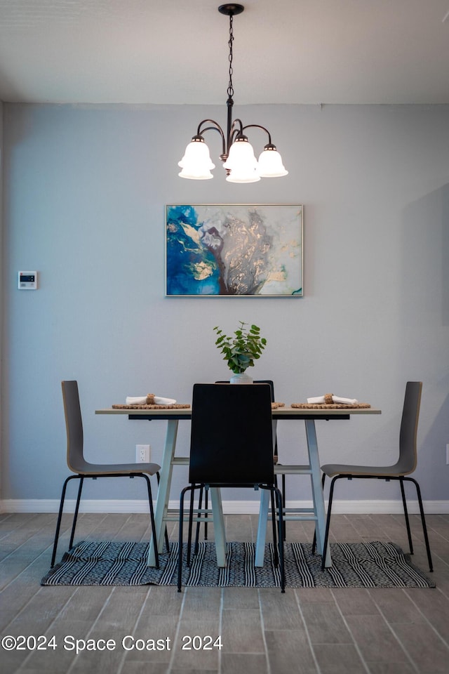 dining space featuring baseboards and an inviting chandelier