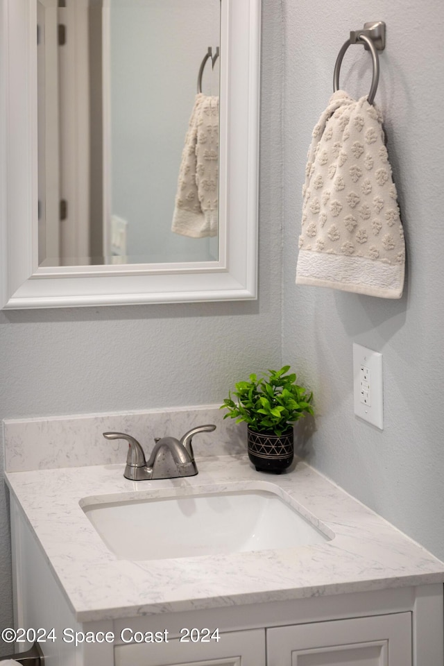 bathroom with a textured wall and vanity