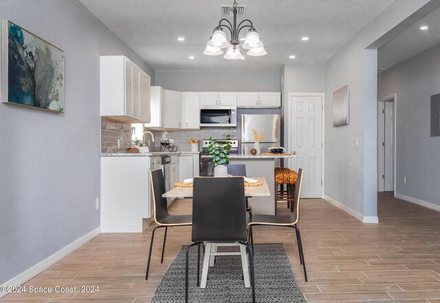 dining area featuring light hardwood / wood-style flooring and a notable chandelier