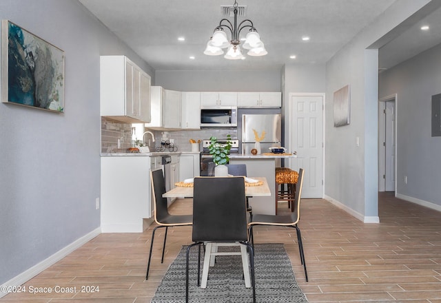 dining space featuring visible vents, baseboards, wood tiled floor, a notable chandelier, and recessed lighting