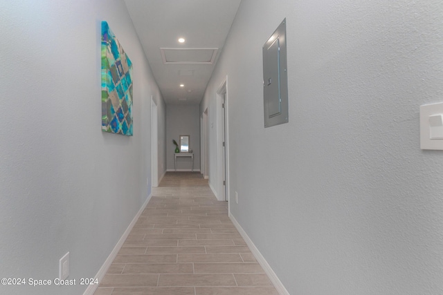 hall featuring attic access, electric panel, baseboards, wood finish floors, and recessed lighting