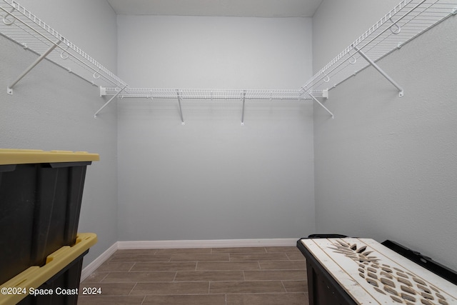 walk in closet with wood finish floors