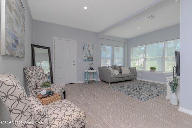 living room featuring light hardwood / wood-style flooring and beam ceiling