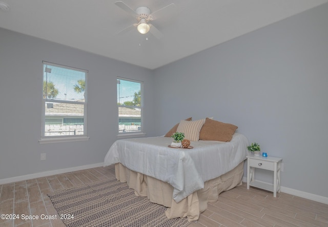 bedroom with baseboards, a ceiling fan, and wood tiled floor