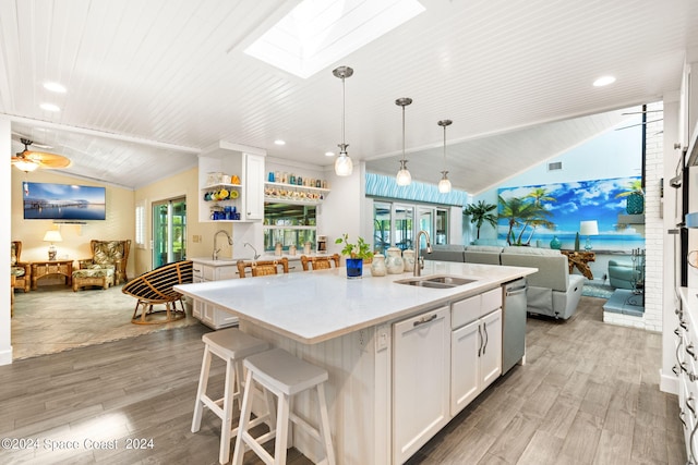 kitchen featuring pendant lighting, a kitchen island with sink, sink, ceiling fan, and white cabinets