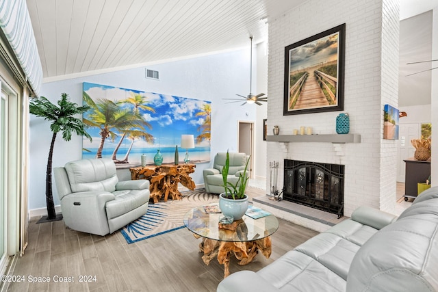 living room featuring light wood-type flooring, high vaulted ceiling, a brick fireplace, and wooden ceiling