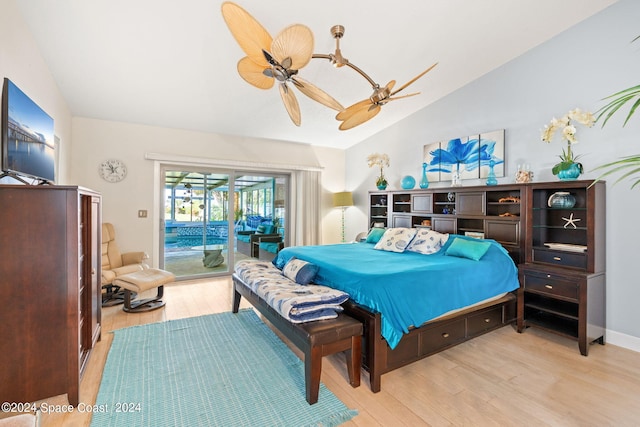 bedroom featuring access to exterior, ceiling fan, light wood-type flooring, and vaulted ceiling