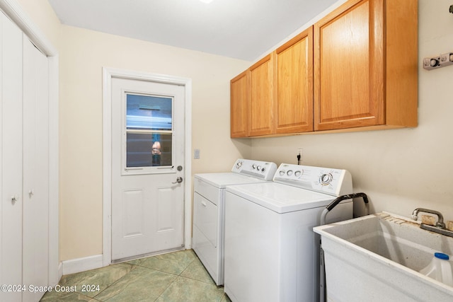 clothes washing area with cabinets, independent washer and dryer, sink, and light tile patterned flooring