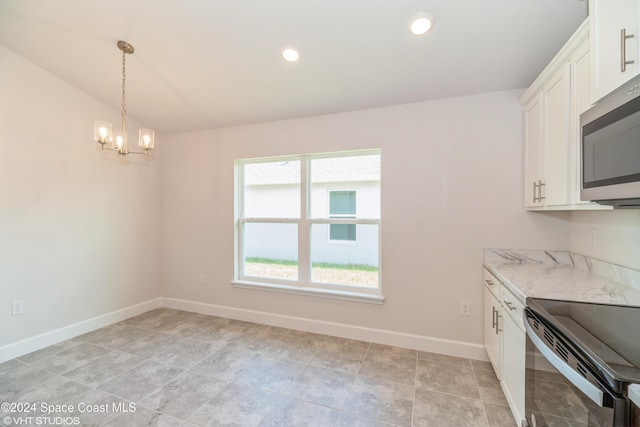kitchen with an inviting chandelier, stainless steel microwave, range with electric cooktop, white cabinets, and baseboards