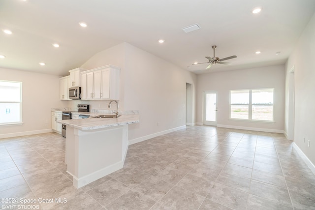 kitchen with a sink, stainless steel appliances, light tile patterned floors, a ceiling fan, and baseboards