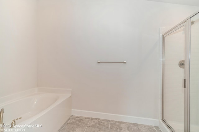 full bath with a garden tub, a stall shower, tile patterned flooring, and baseboards