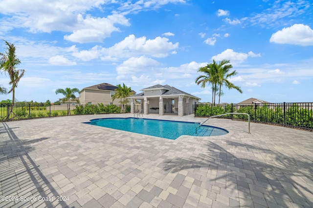 view of pool featuring fence, an outdoor structure, a fenced in pool, and a patio