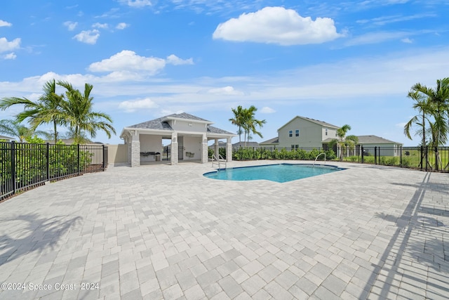 view of swimming pool featuring an outbuilding, a patio, fence, and a fenced in pool