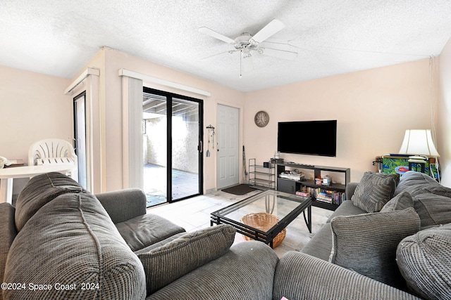 living room with ceiling fan and a textured ceiling