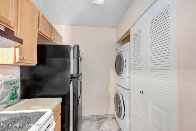 laundry area featuring a textured ceiling and stacked washer / dryer