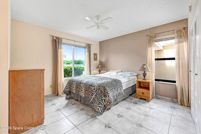 bedroom featuring a textured ceiling, ceiling fan, and a closet