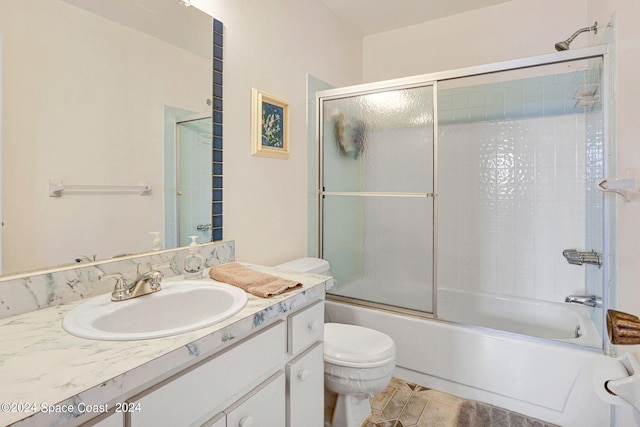 full bathroom featuring shower / bath combination with glass door, vanity, tile patterned flooring, and toilet