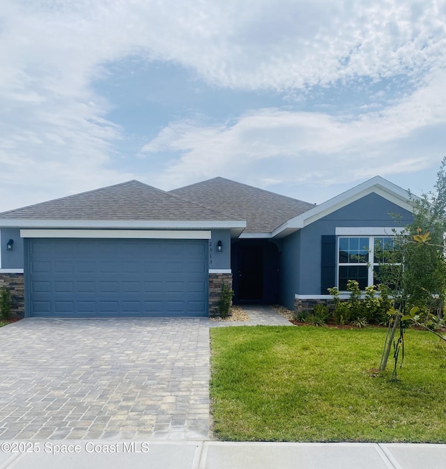 2313 Middlebury Dr SE, Palm Bay, FL 32909 - single story home featuring stone siding, decorative driveway, a front lawn, and a garage