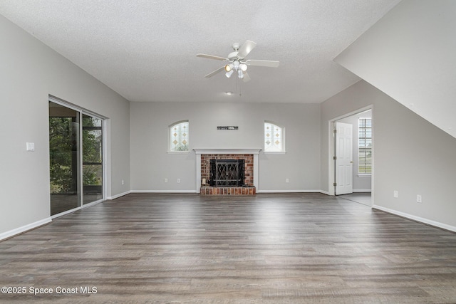 unfurnished living room featuring a brick fireplace, dark hardwood / wood-style floors, and a textured ceiling