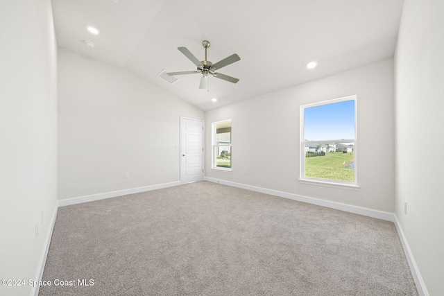 carpeted spare room featuring ceiling fan and lofted ceiling