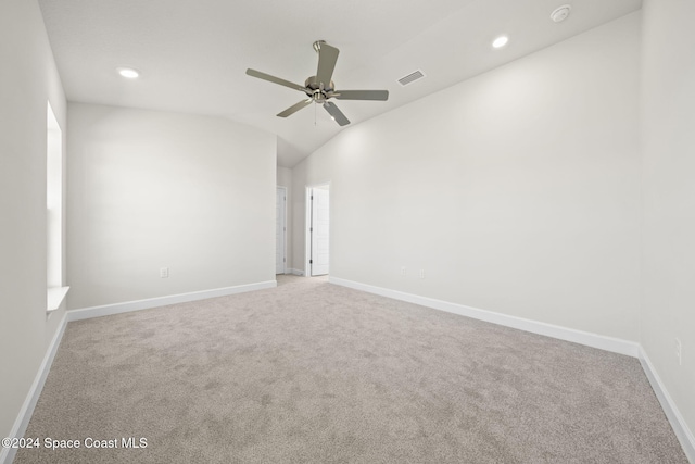 carpeted spare room with ceiling fan and vaulted ceiling