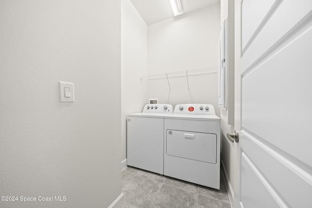 laundry area featuring separate washer and dryer and light tile patterned floors