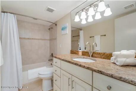 full bathroom featuring tile patterned floors, shower / bath combo, toilet, and vanity