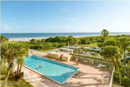 view of pool featuring a water view and a patio