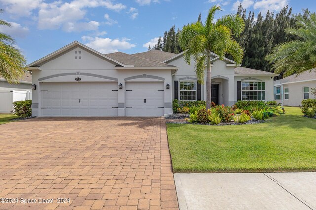 single story home featuring a garage and a front lawn