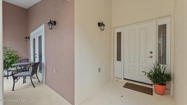 doorway to property featuring stucco siding