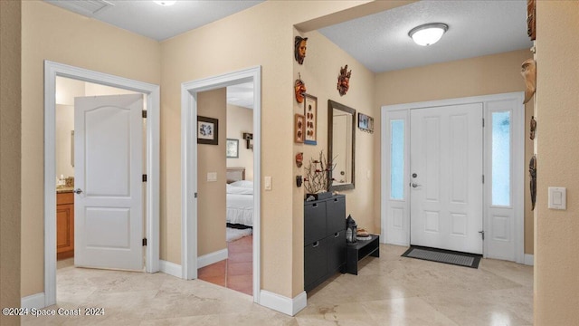 foyer entrance with a textured ceiling