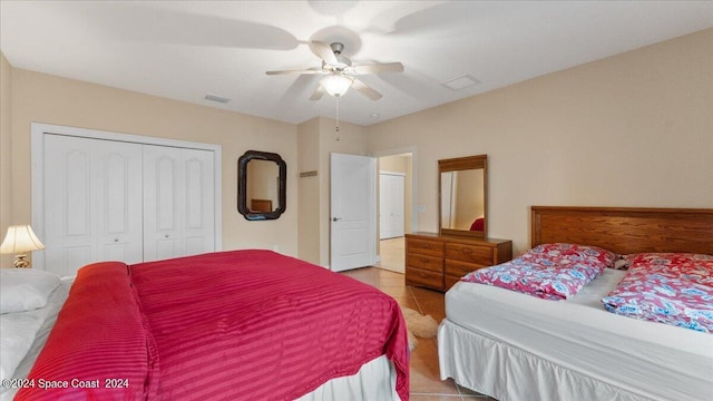 bedroom featuring light tile patterned flooring, ceiling fan, and a closet