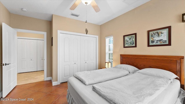 bedroom with a closet, ceiling fan, and light tile patterned flooring