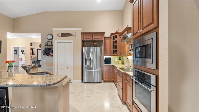 kitchen featuring tasteful backsplash, stainless steel appliances, light stone counters, sink, and ventilation hood