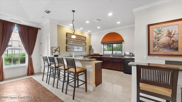 kitchen featuring decorative light fixtures, black dishwasher, light tile patterned floors, a kitchen bar, and crown molding