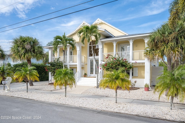 5280 95th St, Sebastian, FL 32958 - view of front of home with french doors, a balcony, stucco siding, and covered porch