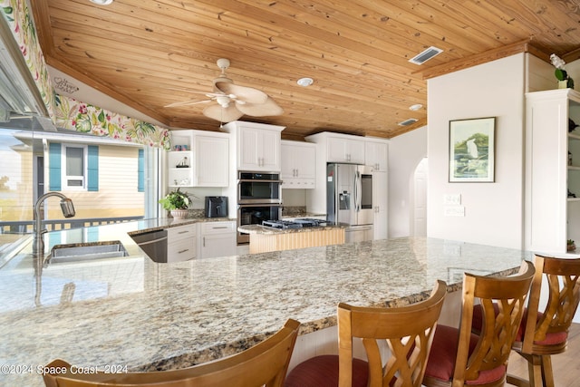 5280 95th St, Sebastian, FL 32958 - kitchen featuring wood ceiling, a ceiling fan, vaulted ceiling, arched walkways, and stainless steel appliances