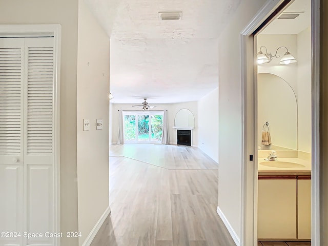 hall featuring sink and light wood-type flooring