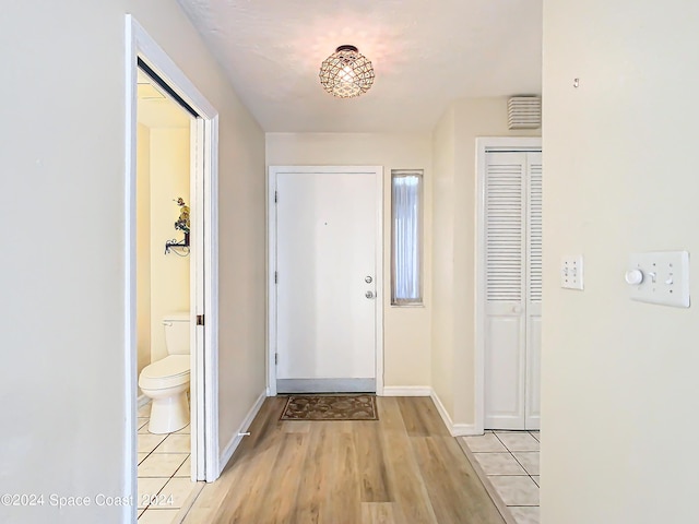 foyer with light tile patterned flooring and baseboards