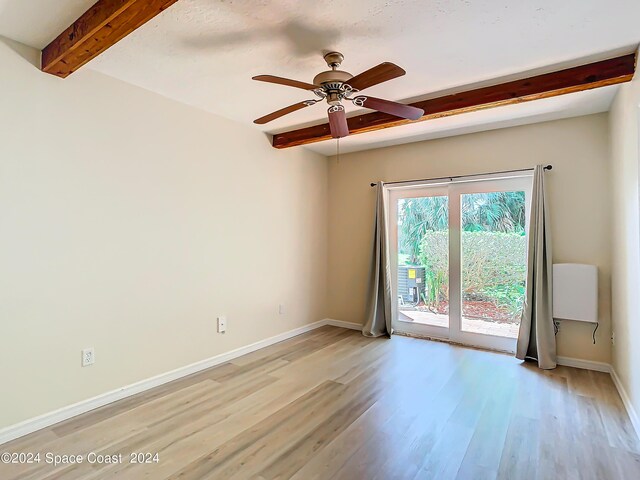 empty room featuring ceiling fan, beam ceiling, and light hardwood / wood-style floors